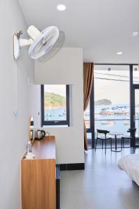 a room with a kitchen with a fan on the wall at Hotel Vũng Găng in Vĩnh Hy