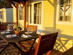 a wooden table on a porch with chairs and a tableasteryasteryasteryasteryastery at Mobile Homes Peroš in Zaton