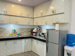 a kitchen with white cabinets and a refrigerator at Sim's Agan South Villas in Lagao III