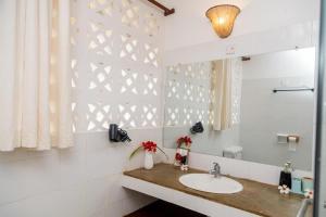 a bathroom with a sink and a mirror at BREEZEACARDEs in Diani Beach +4 photos