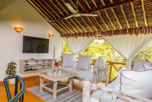 a living room with a couch and a table at BREEZEACARDEs in Diani Beach