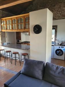 a living room with a clock on a wall at La Casita in Ponteareas +20 photos