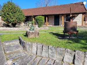 a bench sitting on the grass in front of a house at La Casita in Ponteareas