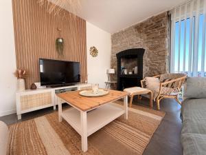 a living room with a table and a tv at El-Argalora-Bihan in Plobannalec-Lesconil