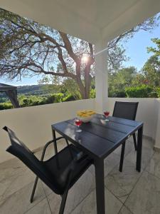 a black table and chairs on a patio with a tree at Blagdan apartments in Palit