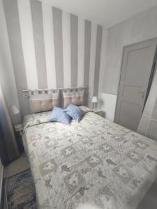 a bedroom with a bed with two blue pillows at Appartamento in Villa in Mondaino