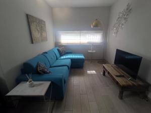 a living room with a blue couch and a tv at Appartamento in Villa in Mondaino