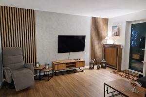 a living room with a television and a chair at Waldpanorama Schildberg in Lügde