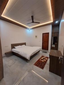 a bedroom with a bed and a ceiling at MG Stay AYODHYA in Faizābād +3 photos