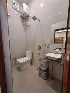 a bathroom with a toilet and a sink at MG Stay AYODHYA in Faizābād