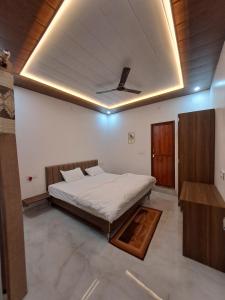 a bedroom with a bed in a room with a ceiling at MG Stay AYODHYA in Faizābād