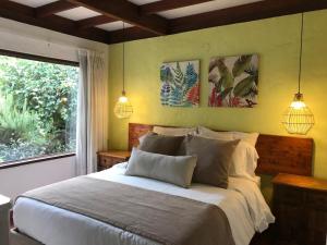 a bedroom with a bed with two lamps and a window at Chalet Andino Sesquile in Suesca +76 photos