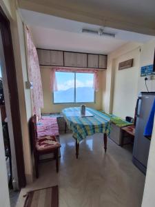 a living room with a table and a bed at Himavati Retreat in Darjeeling