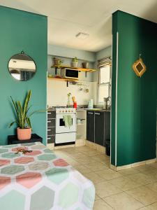 a kitchen with a bed and a green wall at Altos de Barrio Sur in San Miguel de Tucumán