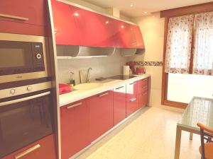 a kitchen with red cabinets and a sink at Av Valladolid 45 in Soria +20 photos