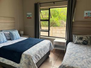 a bedroom with two beds and a window at Su Casa Port Alfred in Port Alfred