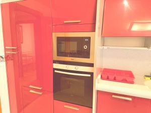 a kitchen with red cabinets and a microwave at Av Valladolid 45 in Soria