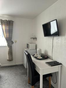a room with a desk with a tv on the wall at Tay Villa in Inverness