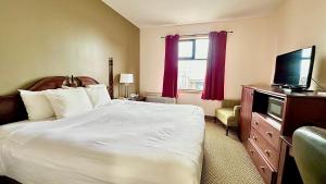 a bedroom with a bed and a flat screen tv at Econo Lodge City Centre in Kingston