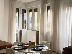 a room with a table and chairs and windows at 1402 Rooms in Matera