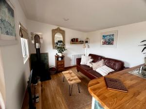 a living room with a couch and a table at The Cabin at Swelle Cottages in Poundstock