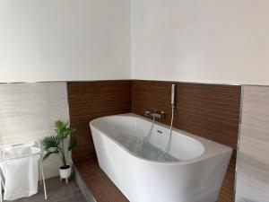 a white tub in a bathroom with a plant at 1402 Rooms in Matera