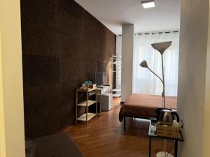 a room with a bed and a table with a lamp at 1402 Rooms in Matera