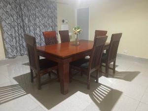 a wooden table with chairs and a vase with flowers at MableHomestay in Mzuzu +12 photos