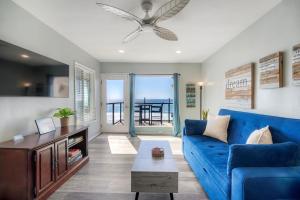 a living room with a blue couch and a table at Oceanfront Condo, Private Balcony, Beach Access, Sunset Views in Carlsbad