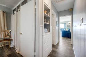 a hallway with white cabinets and a blue couch at Oceanfront Condo, Private Balcony, Beach Access, Sunset Views in Carlsbad