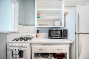 a kitchen with a stove and a microwave at Oceanfront Condo, Private Balcony, Beach Access, Sunset Views in Carlsbad