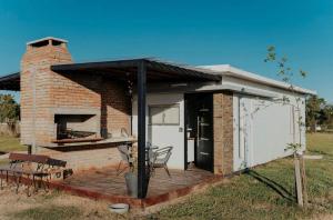 a brick building with a deck with a grill at La Finca 2 in Mercedes