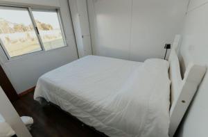 a white bed in a room with a window at La Finca 2 in Mercedes