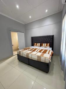 a bedroom with a large bed in a room at Davidson Lodge in Goodwood