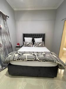 a bed with a black and white comforter in a bedroom at Davidson Lodge in Goodwood