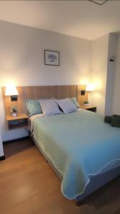 a bedroom with a large bed with blue sheets and pillows at Urban Escape Sky View in Cochabamba +13 photos