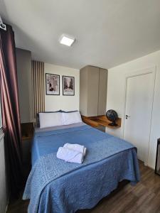 a bedroom with a bed with a blue blanket at 200m metro bras com Piscina in São Paulo