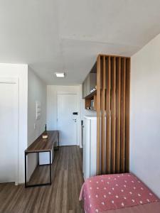 a bedroom with a desk and a table and a kitchen at 200m metro bras com Piscina in São Paulo