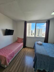 a hotel room with two beds and a window at 200m metro bras com Piscina in São Paulo