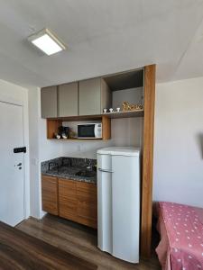 a small kitchen with a refrigerator and a counter at 200m metro bras com Piscina in São Paulo +35 photos