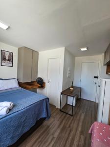 a bedroom with a blue bed and a table at 200m metro bras com Piscina in São Paulo