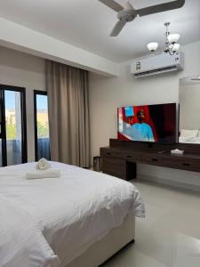 a bedroom with a bed and a flat screen tv at Qala View Inn in Nizwa