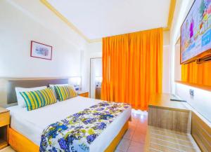 a bedroom with a bed with an orange curtain at ESMA CLOVE RESORT&SPa in Eskiömerler