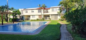 a house with a swimming pool in front of a yard at Casa Totalmente Equipada en Acapulco Diamante in Acapulco