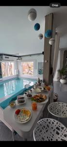a table with plates of food next to a swimming pool at Catalpa in Al Ḩārah