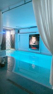 a swimming pool with a tv in a room at Catalpa in Al Ḩārah