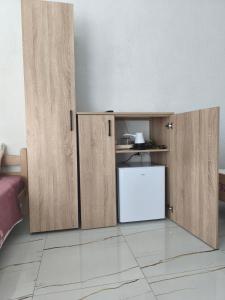 a kitchen with wooden cabinets and a white refrigerator at Rooms Kirovi - Star Dojran in Star Dojran