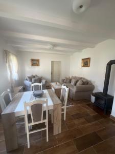 a living room with a table and chairs and a couch at Sasovici farmstay in Magazini