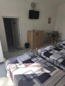 two beds in a room with a tv on the wall at Rooms Kirovi - Star Dojran in Star Dojran
