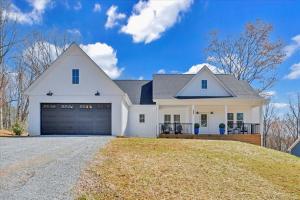 a white house with a garage on a hill at Lake Twin Cove - New! in Moneta